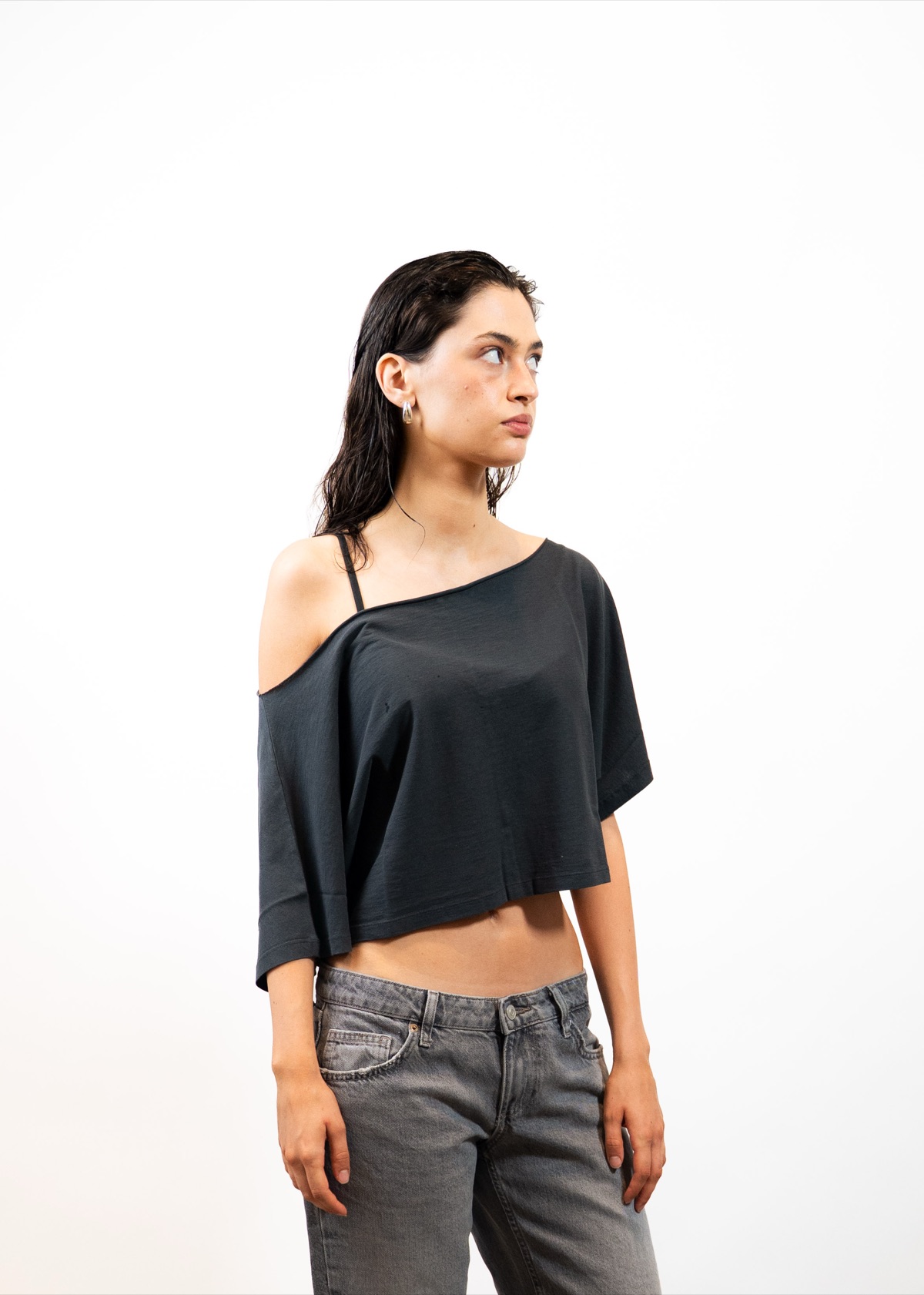 Outryght Wintershoot: Model in schwarzem Off-Shoulder-Top, seitlich im Studio fotografiert